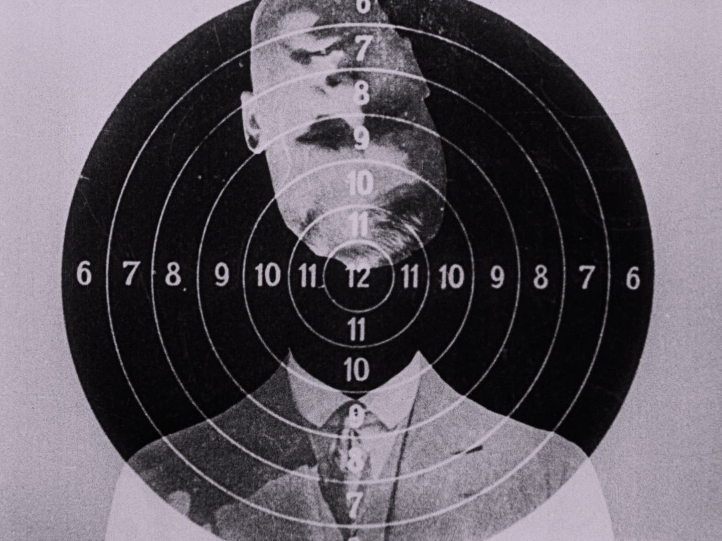 A black-and-white portrait of a man in a suit superimposed over a circular target.